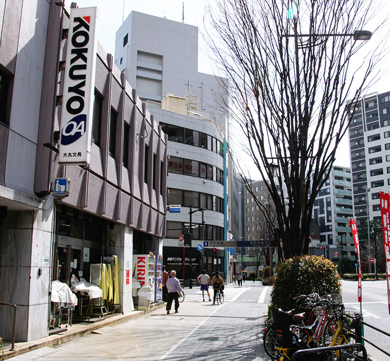 「moRiRin」ビルを左手に見ながらまっすぐ進むと，ひとつ目の信号（東日本橋）の交差点に出ます。<br>交差点手前の「KOKUYO」の看板の大丸文具が目印です。